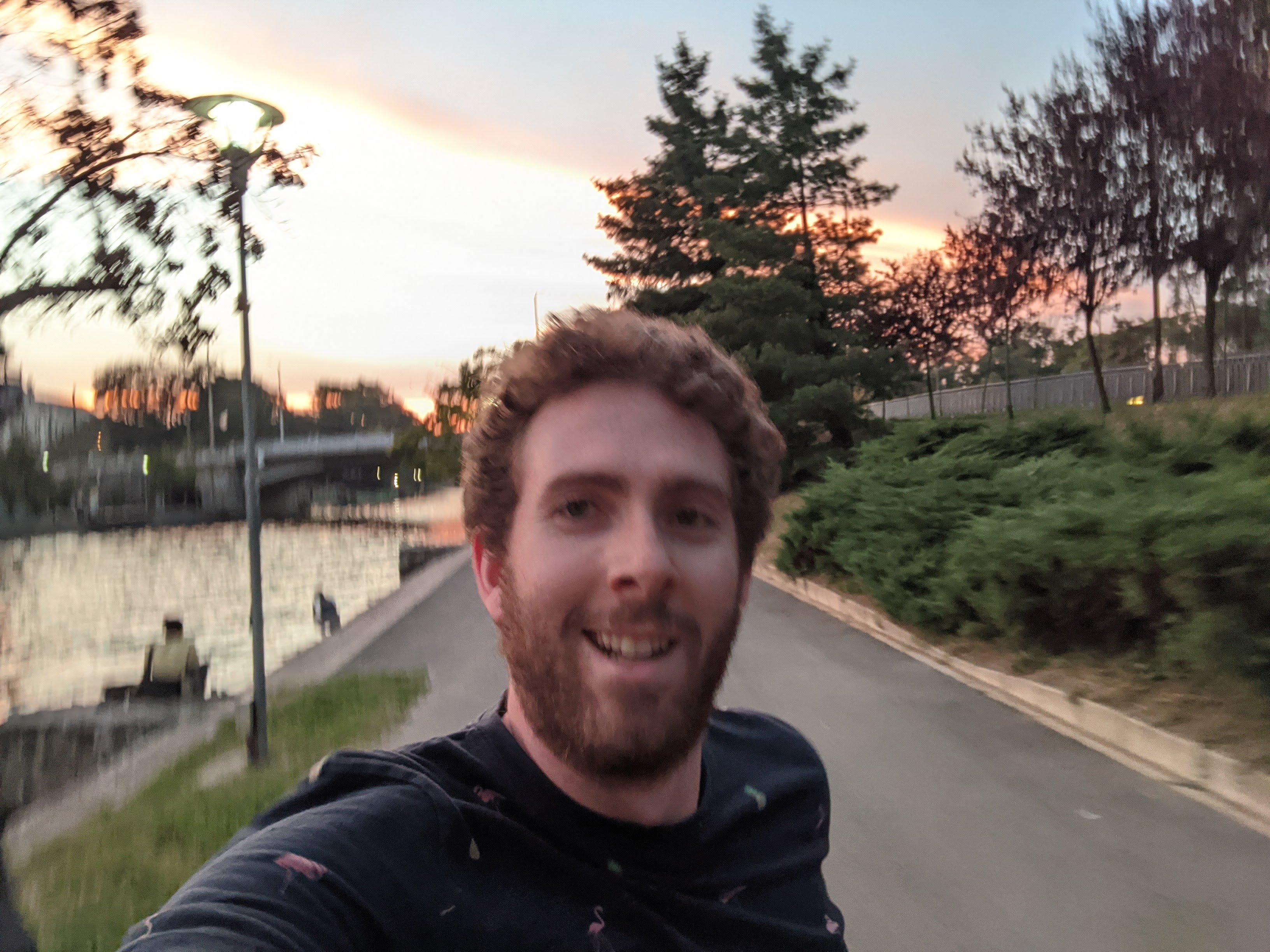 Selfie of me running in front of a nice city park with a fountain and church.